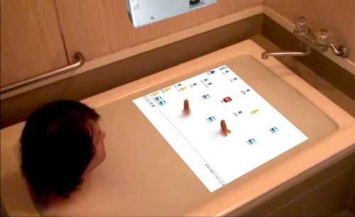 guy sitting in bathtub, with interaction surface projected on water