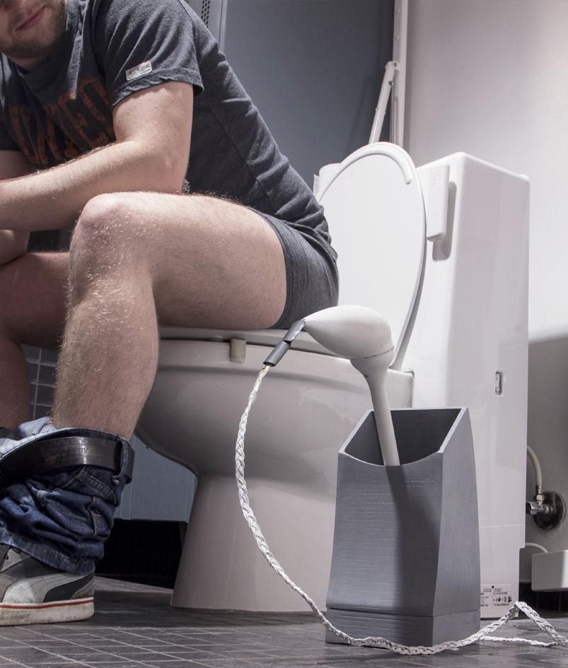 person sitting on toilet, toilet brush with wires hanging out